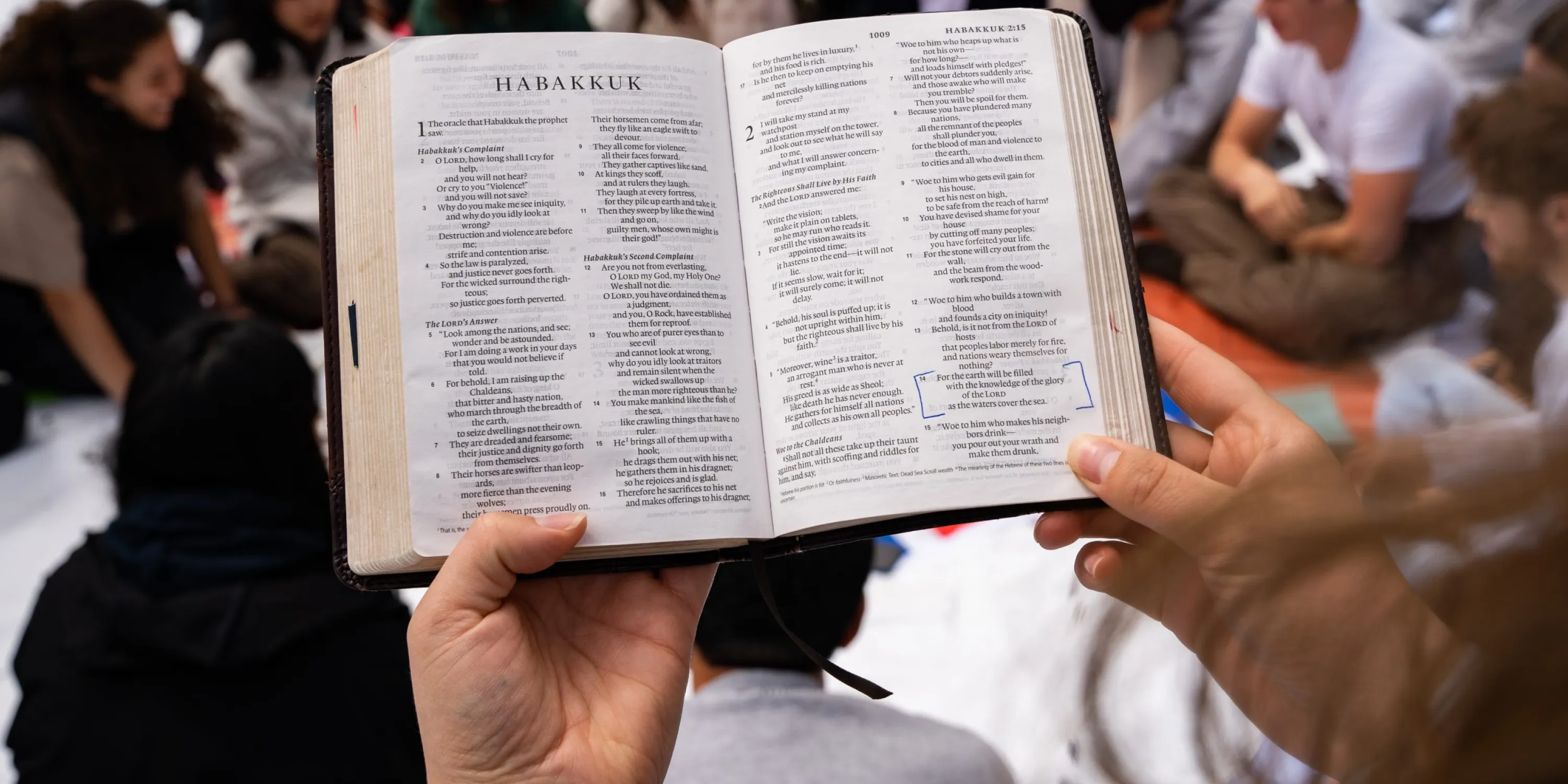 A close up image of a bible held up by the hands of a student.