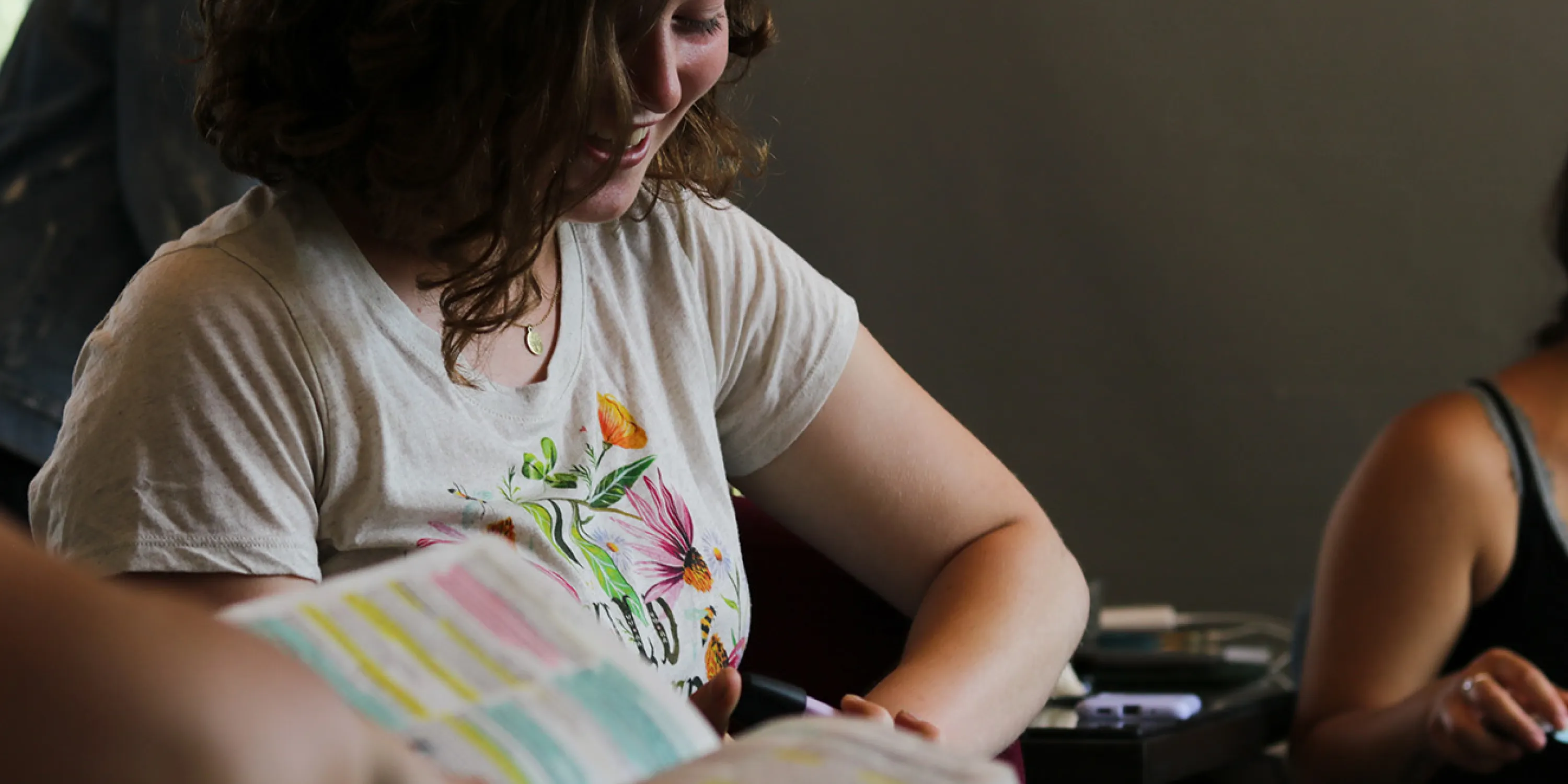 A close up image of a seated female student looking down and smiling.