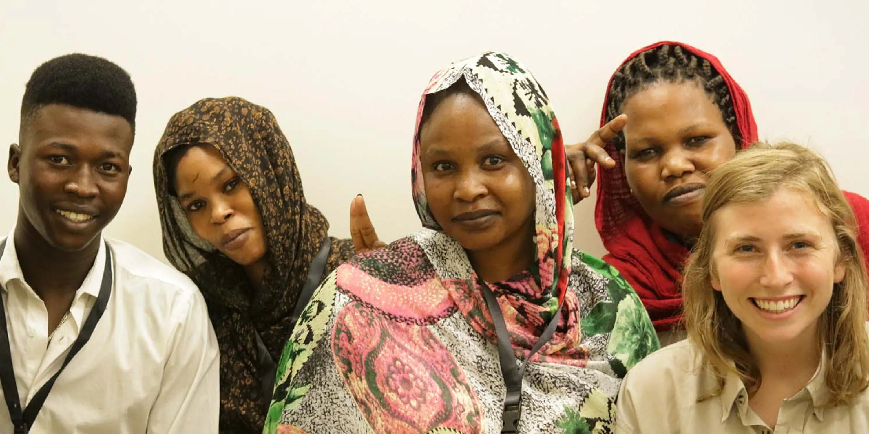 A group of five young adults smiling at the camera.