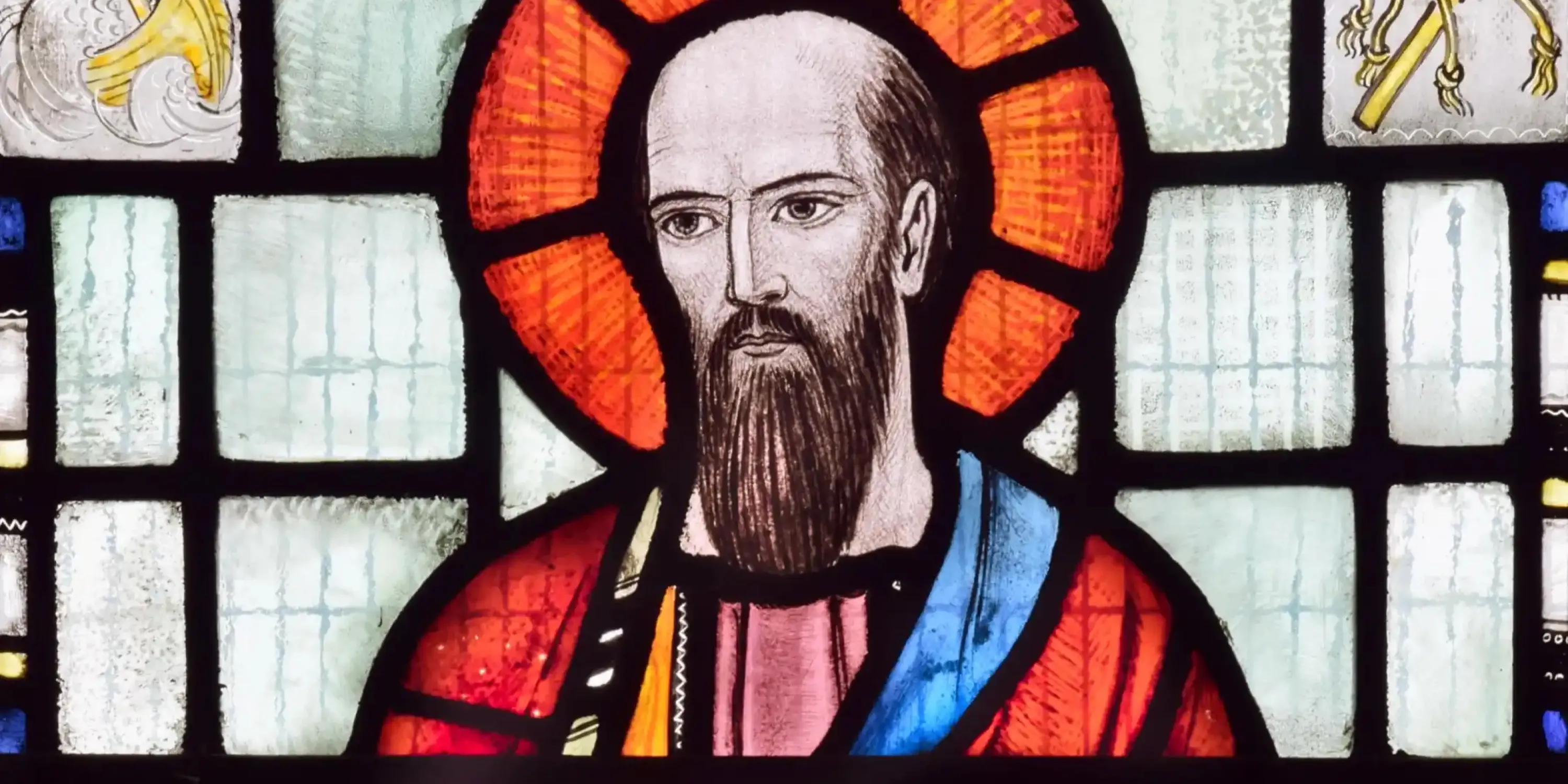 An image of a stained glass window of Paul the Apostle.