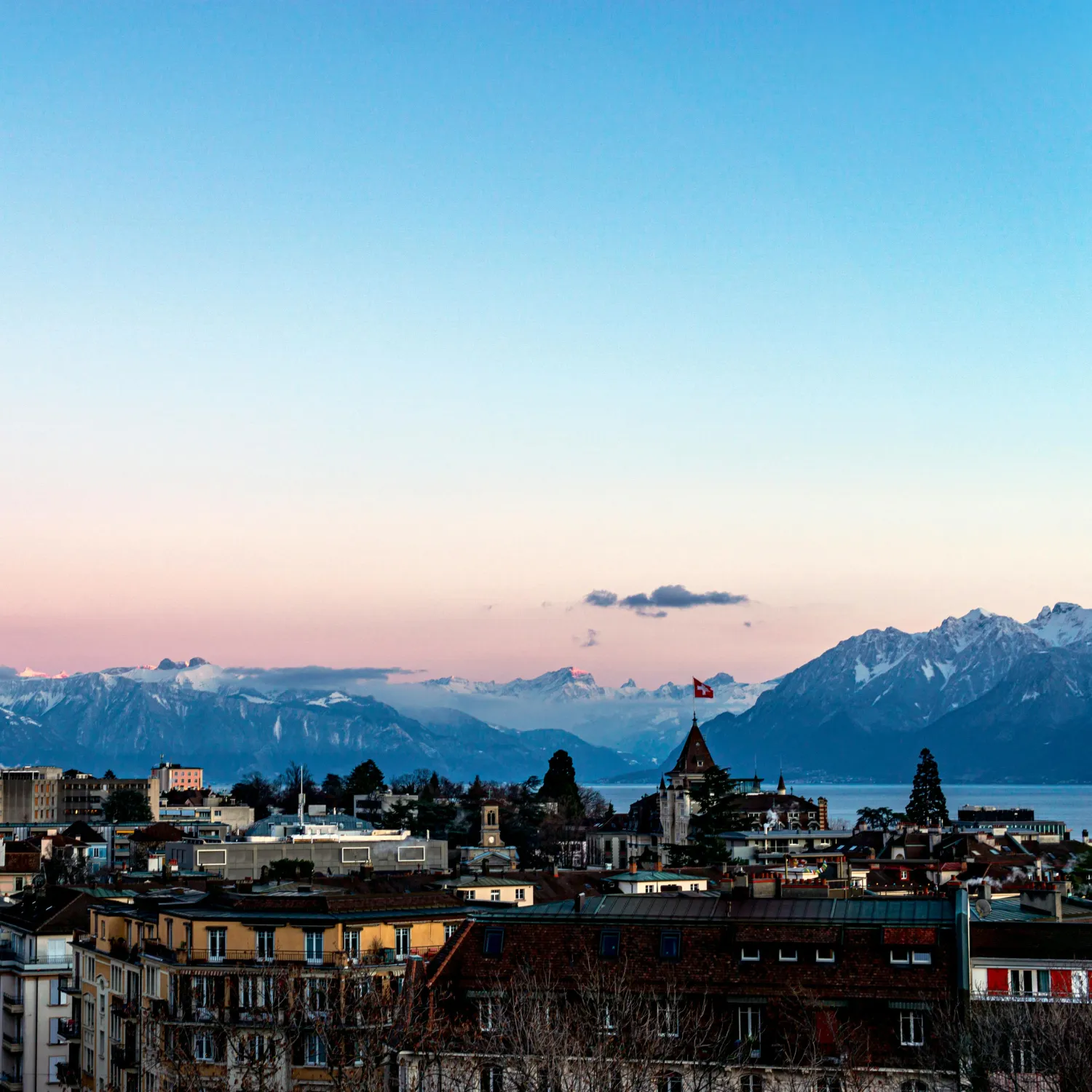 A cityscape of Switzerland with a lake and mountains in the backdrop during DTS at YWAM Lausanne.