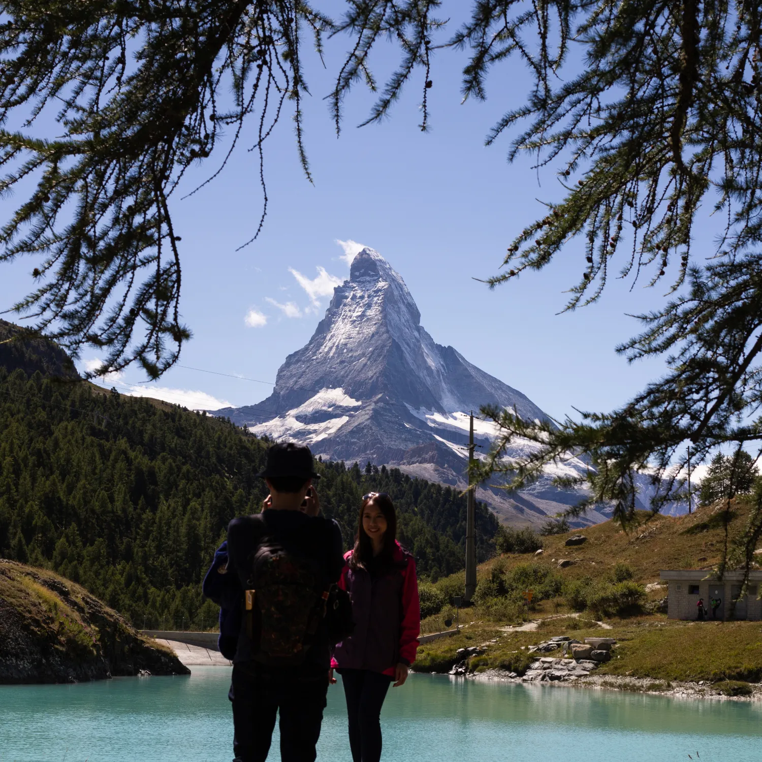 Two YWAM Lausanne students posing for a photo in front of a snowy capped mountain in Switzerland.
