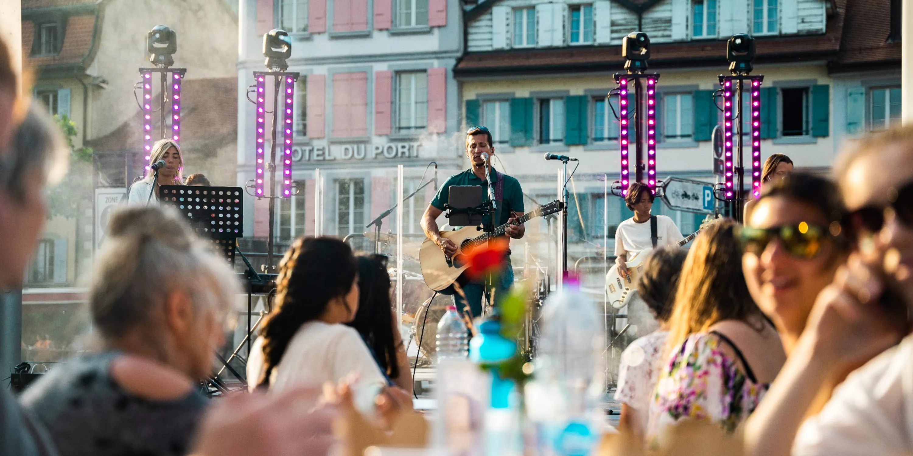 A crowd of students listening to performers on an outdoor stage.