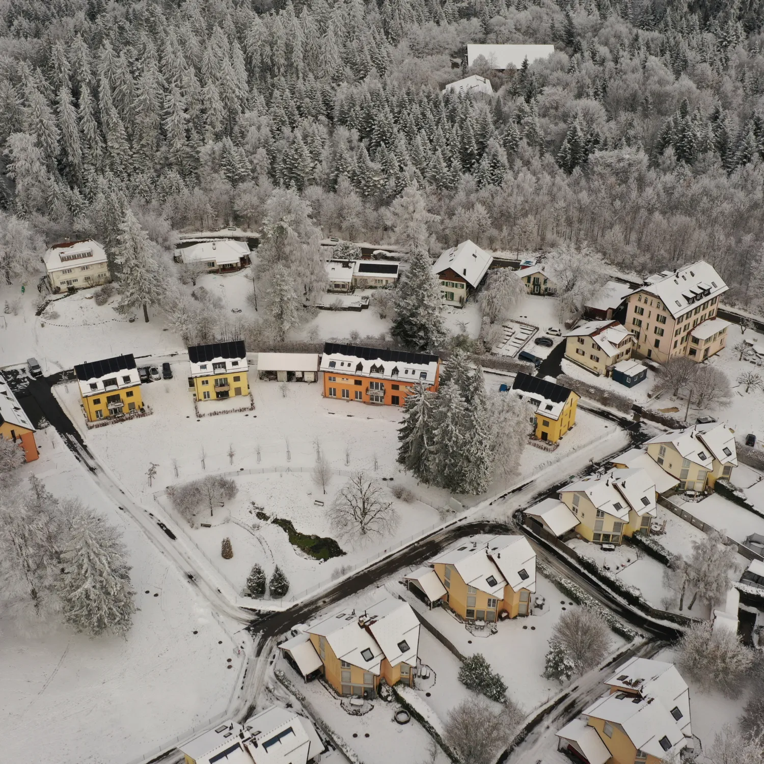 Overhead image of buildings and trees covered in snow.