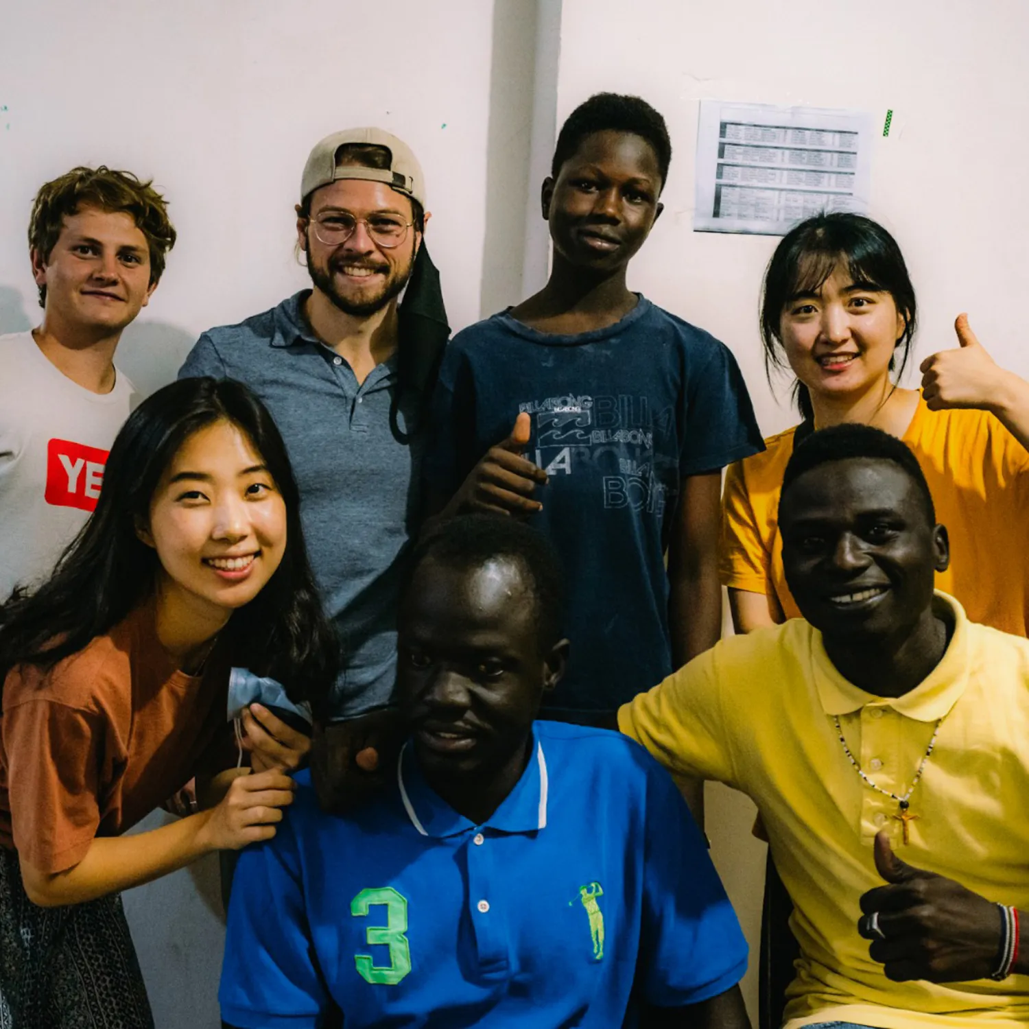 A group of young men and women of different ethnicities smiling at the camera.