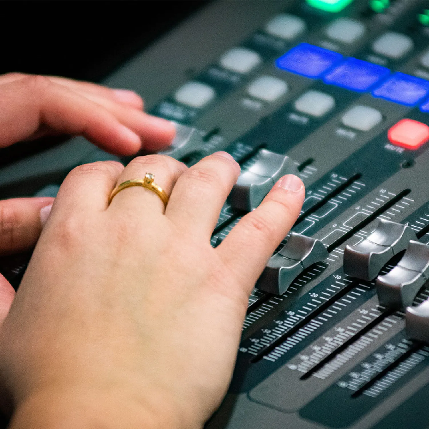 A close up image of a hand working on a sound system during worship.