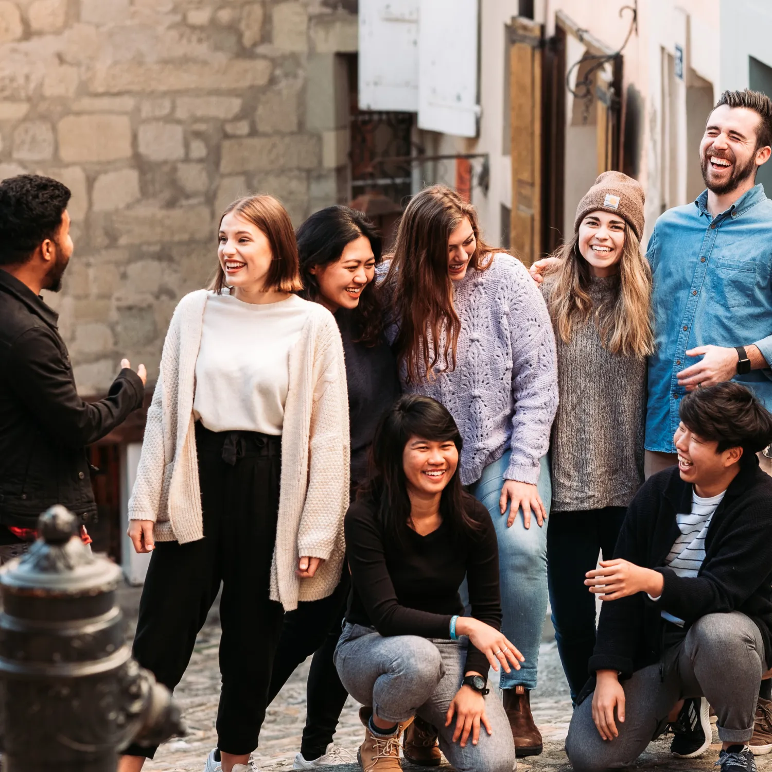 A group of diverse students standing and smiling in a city street.